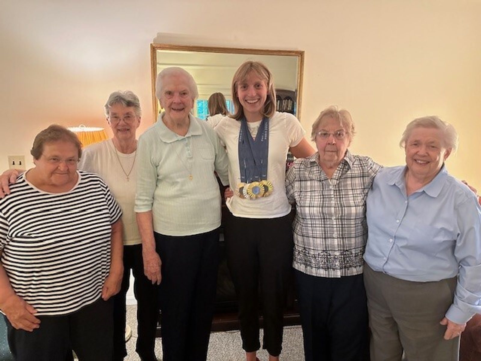 After winning four medals at the 2024 Summer Olympic Games in Paris, champion swimmer Katie Ledecky visited the Immaculate Heart of Mary sisters at their convent at the Church of the Little Flower in Bethesda, Maryland. Ledecky and her family are parishioners there, and she graduated from Little Flower School in 2011. From left to right are Sister Madonna Lenikus, Sister Ann Parker, Sister Rosemaron Rynn, Katie Ledecky, Sister Ritamary Mayan and Sister Jane Mary Duke. (Courtesy photo)