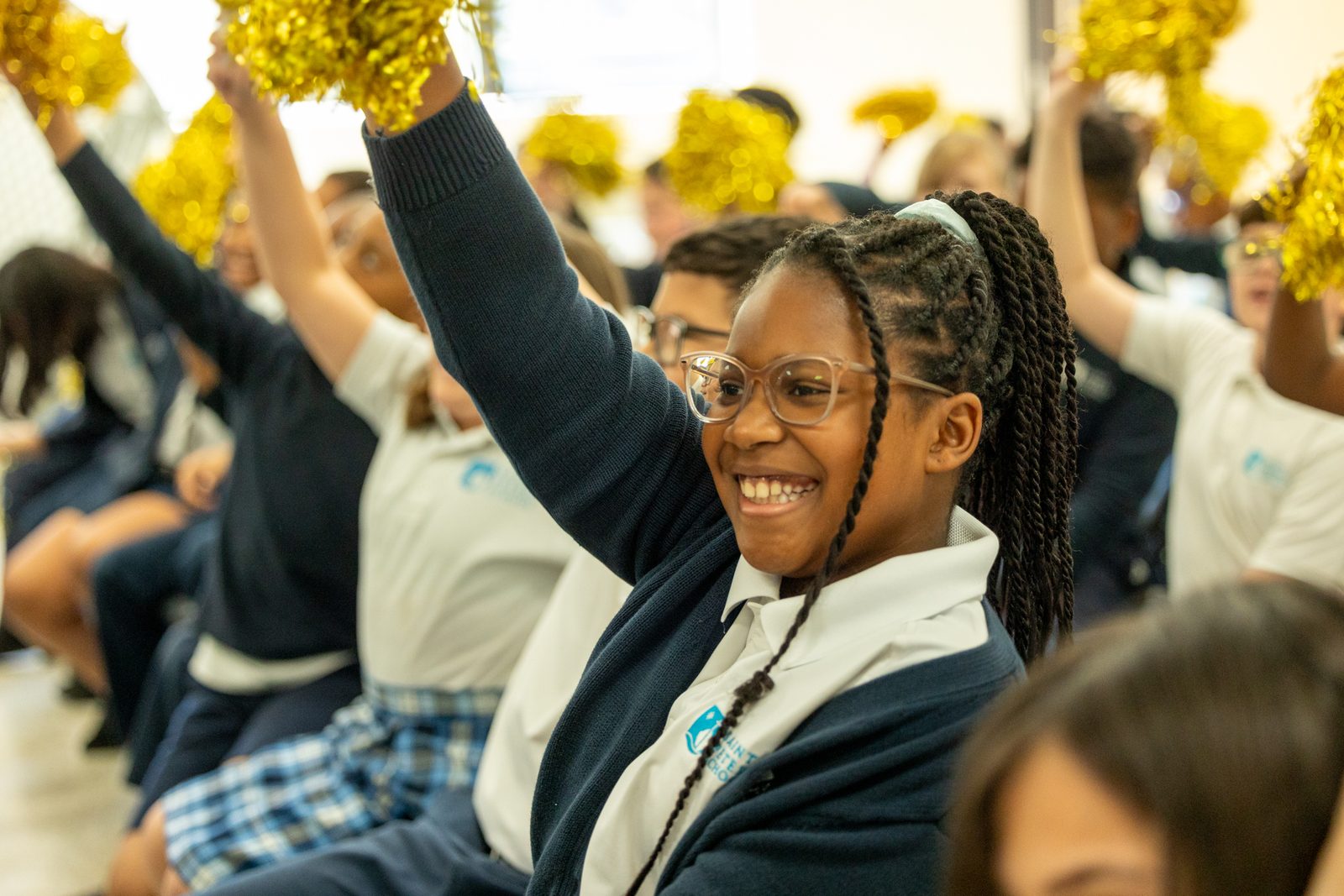 Fourth grader Ameiah Brunson of Saint Peter’s School in Waldorf shakes a gold-colored pom-pom as she joins fellow students on April 15 as they cheer for third grade teacher Margo VanDenBossche, who was announced as a 2024 Golden Apple Award winning teacher in The Roman Catholic Archdiocese of Washington. (Catholic Standard photo by Mihoko Owada)