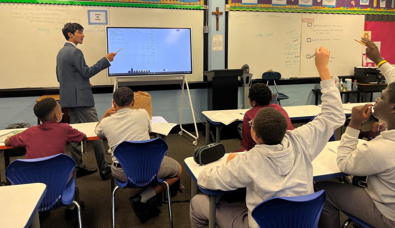In a photo from May 2024, Zayd Patel now a senior at The Heights School in Potomac, Maryland – teaches math to middle school students in an after-school program at St. Francis Xavier Catholic Academy in Washington, D.C. The students raising their hands at right are Matthew Moore, then a St. Francis Xavier seventh grader, and Frederick Emodi, then an eighth grader there. (Catholic Standard photo by Mark Zimmermann)