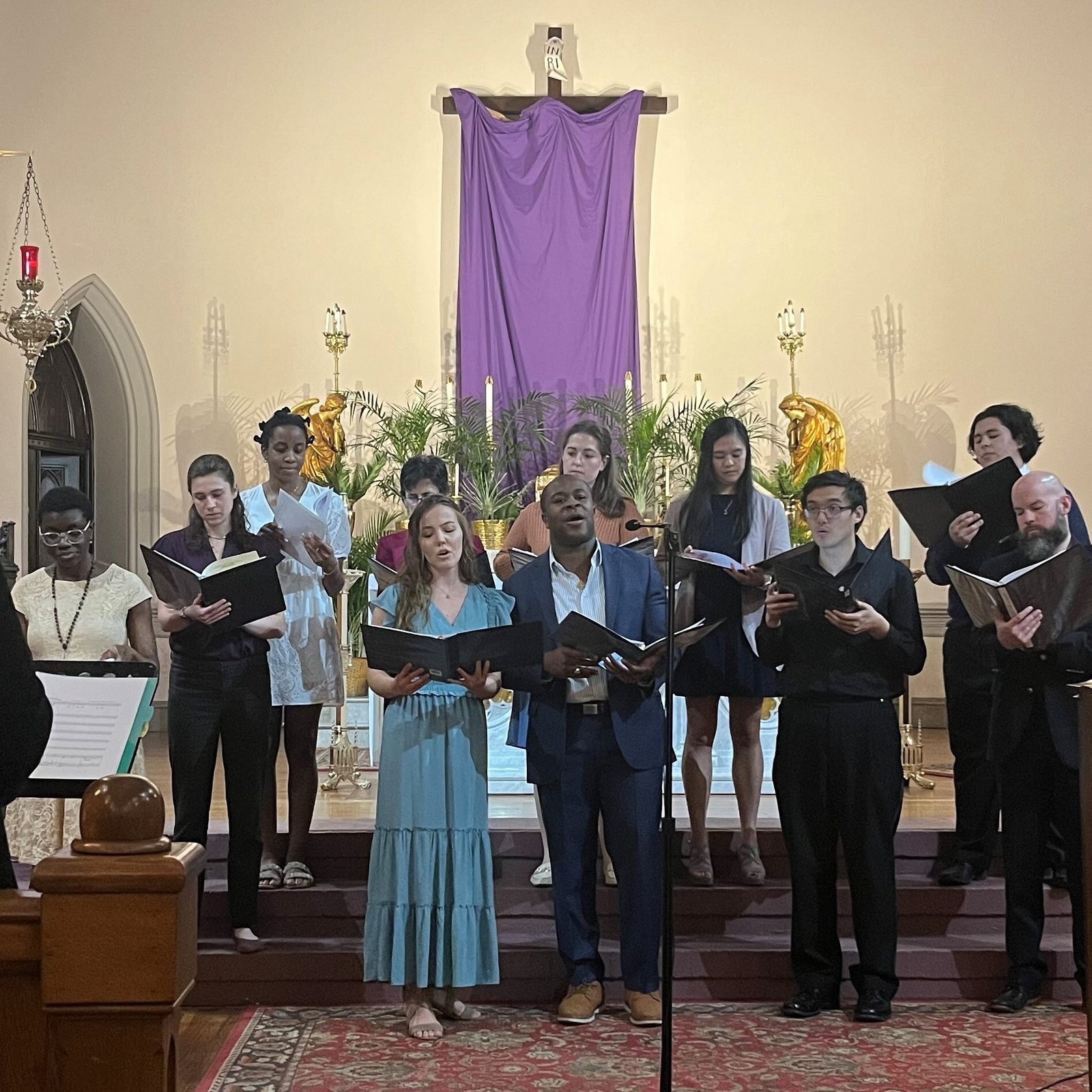 During the “Come As You Are” Holy Week Prayer Service for Mental Health at St. Joseph Church on Capitol Hill in Washington, D.C., on March 26, Hannah Benson and Anebi Adoga at center sing a duet as they are joined by other choir members. Benson is a member of the Pentagon City Congregation of the Church of Jesus Christ of Latter-Day Saints, and Adoga is a D.C. corporate lawyer who worships at Catholic churches in Baltimore and the nation’s capital and who helped organize the prayer service. At right in the background is Father William Gurnee, the pastor of St. Joseph Parish. (Catholic Standard photo by Mark Zimmermann)