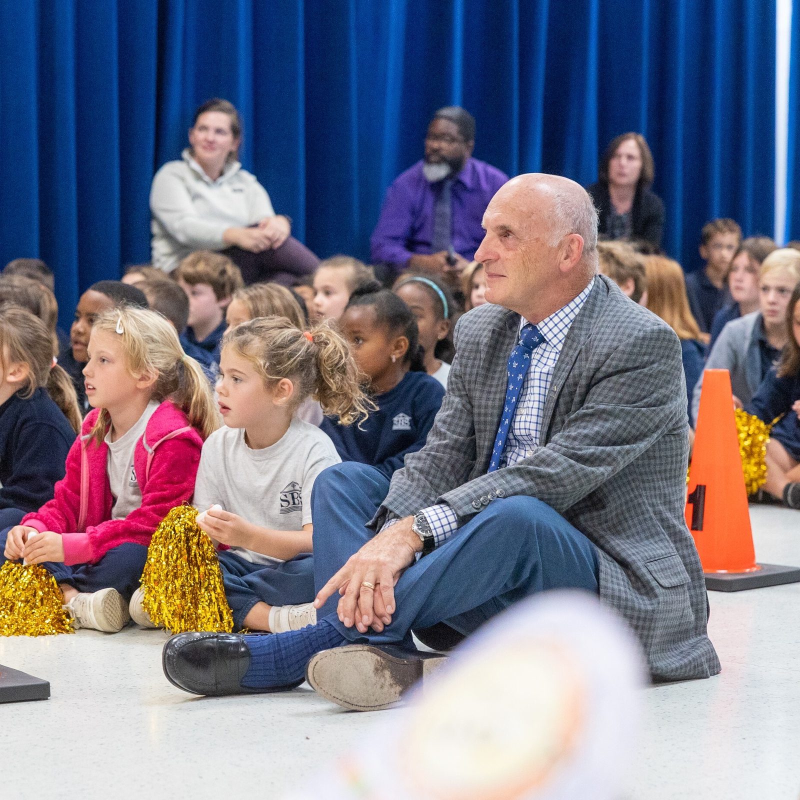 Ted Ewanciw, the principal of St. Bernadette School in Silver Spring, sits with students during a surprise ceremony on Oct. 10 in the school hall, where it was announced that he is the Roman Catholic Archdiocese of Washington’s 2025-2026 Distinguished Principal of the Year. (Catholic Standard photo by Mihoko Owada)