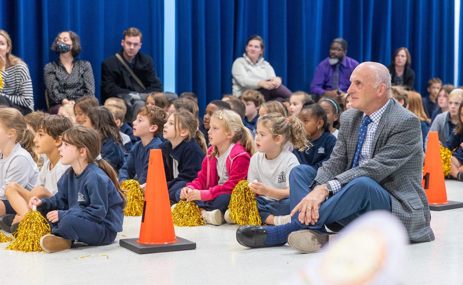 Ted Ewanciw, the principal of St. Bernadette School in Silver Spring, sits with students during a surprise ceremony on Oct. 10 in the school hall, where it was announced that he is the Roman Catholic Archdiocese of Washington’s 2025-2026 Distinguished Principal of the Year. (Catholic Standard photo by Mihoko Owada)
