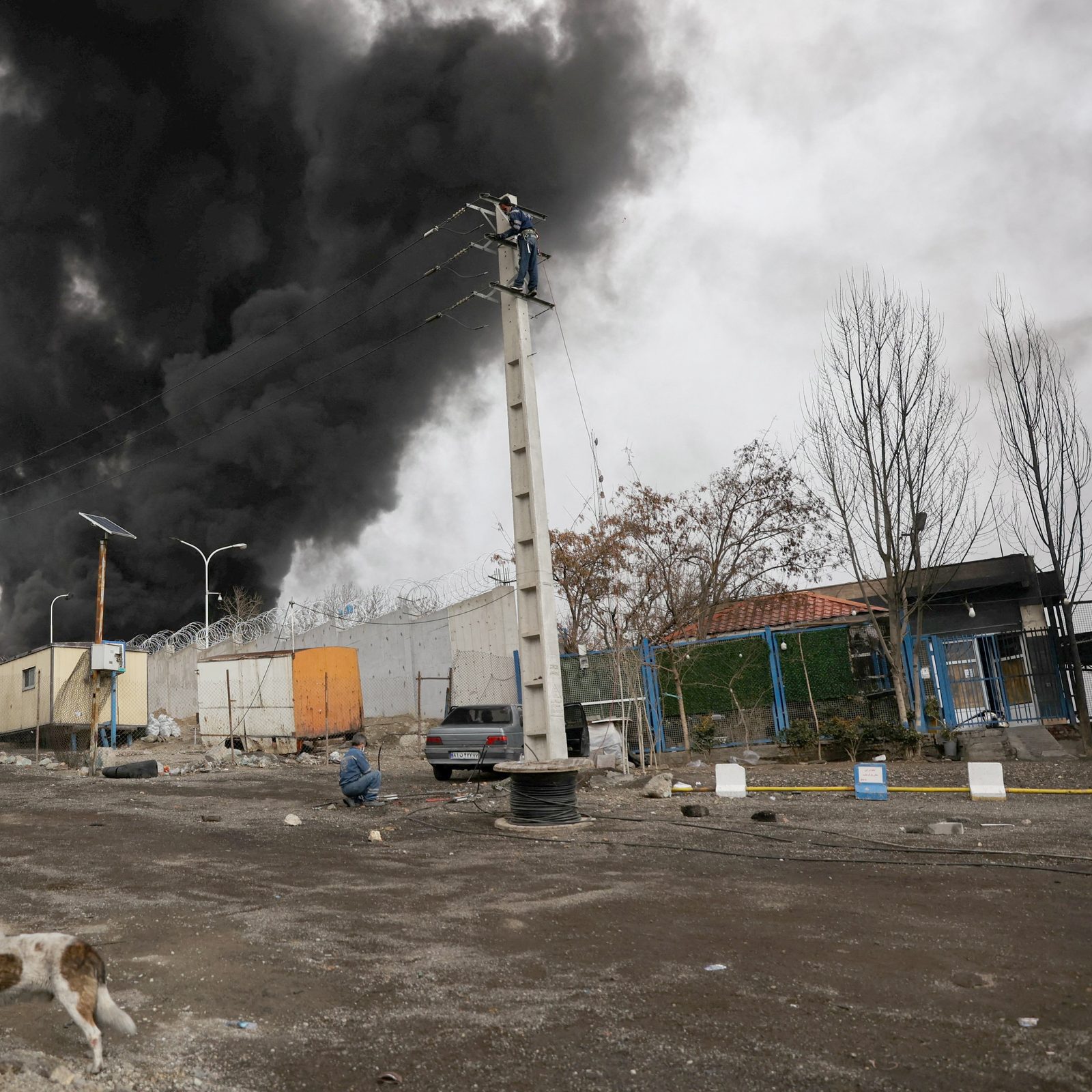 People look on and take photos as smoke rises after reported Israeli airstrikes on Shahran fuel tanks in Tehran, Iran, March 8, 2026, amid the U.S. and Israel-Iran war. (OSV News photo/Majid Asgaripour, WANA via Reuters)