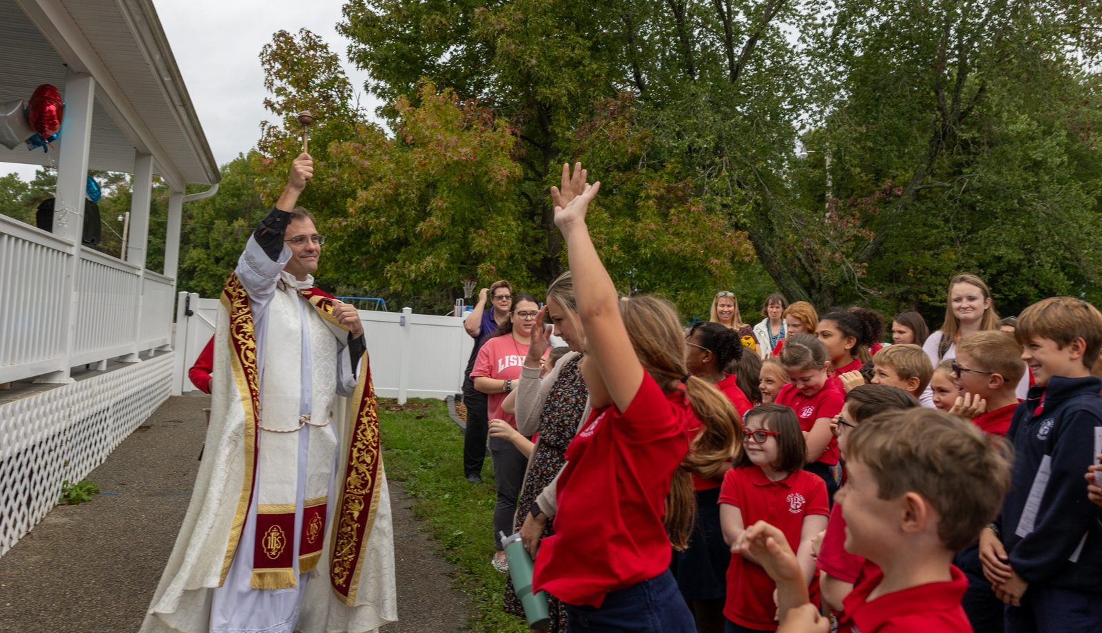 Father Scott Holmer, the pastor of Holy Face Parish in Great Mills, Maryland, sprinkles holy water on students from Little Flower School in Great Mills after blessing the school’s new Early Learning Center on Oct. 1, 2024. (Catholic Standard photo by Mihoko Owada)