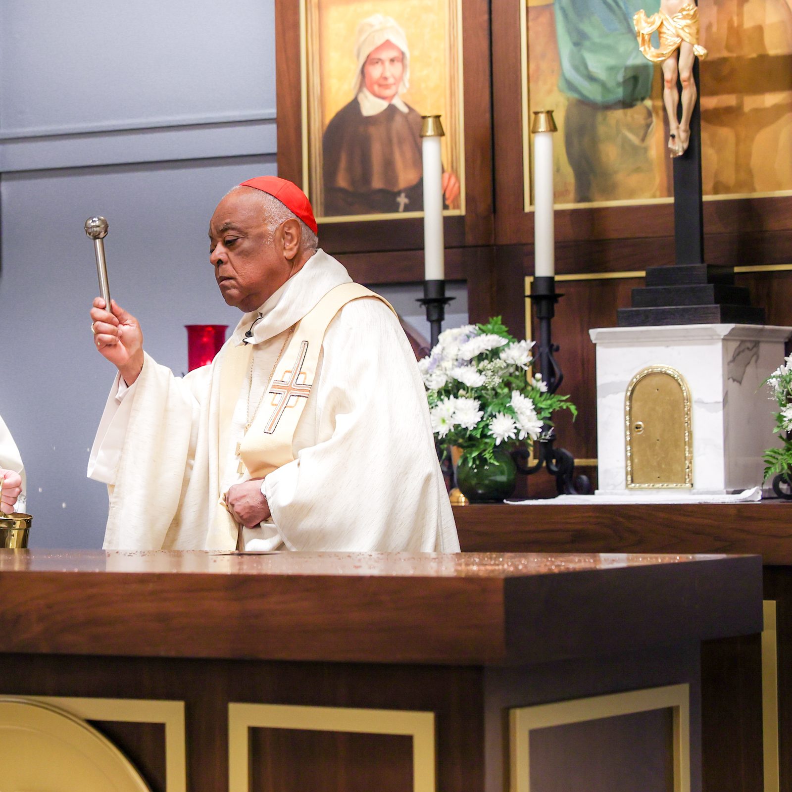 During a June 5, 2024 Mass at St. Mary’s Ryken High School in Leonardtown, where Cardinal Gregory blessed the new altar at the school’s renovated Chapel of Charity, the cardinal sprinkles holy water on the altar. At left is Father Kevin Regan, the cardinal’s priest secretary. (Photo by HD Photography for St. Mary’s Ryken High School)