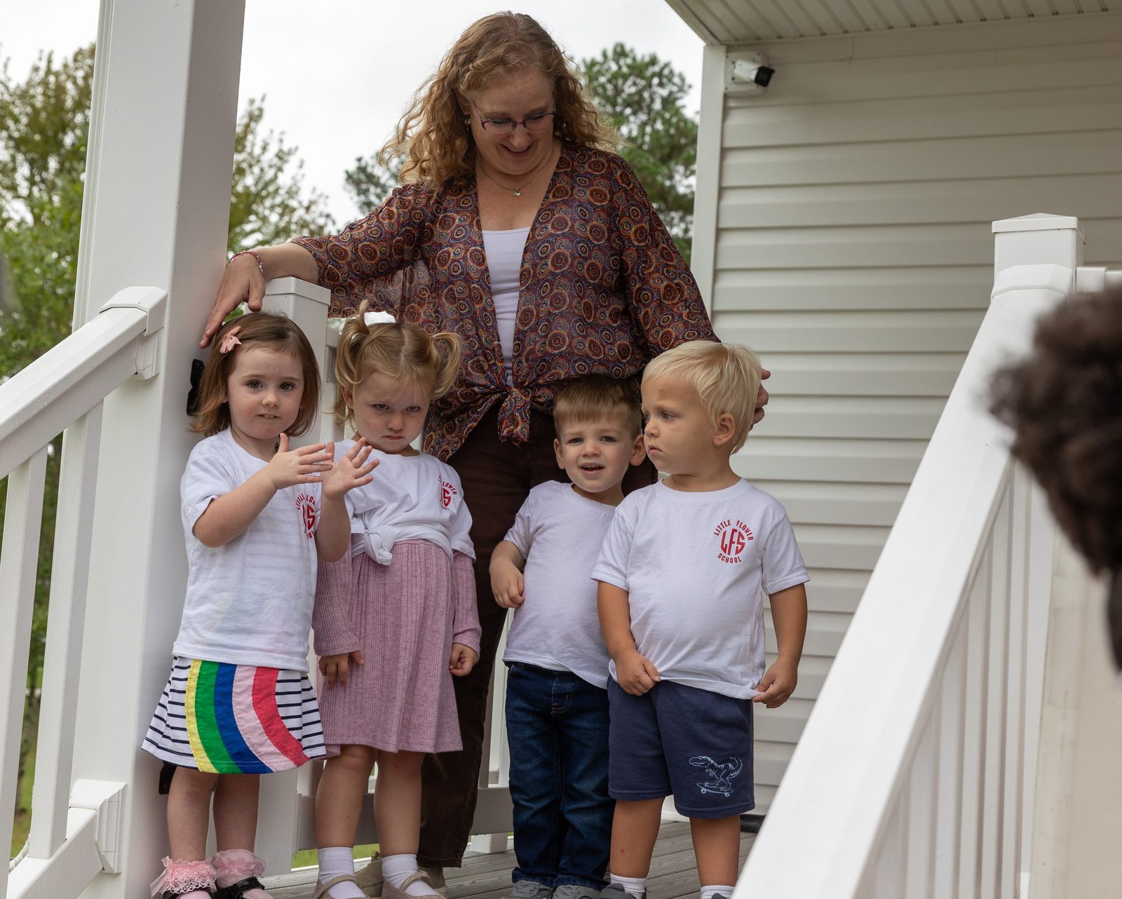 Jean Beyer, the lead teacher at the new Early Learning Center at Little Flower School in Great Mills, Maryland, poses for a photo with four of her 2-year-old students who watched a ribbon-cutting ceremony on Oct. 1, 2024 when the center was blessed. (Catholic Standard photo by Mihoko Owada)