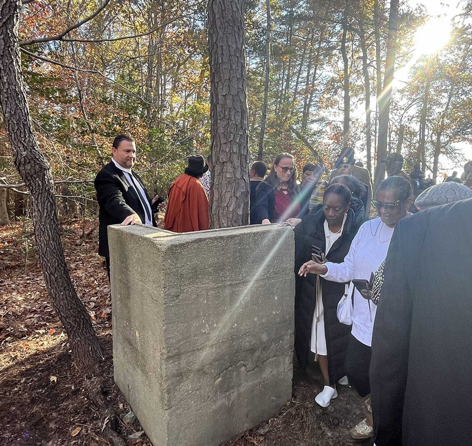 During a pilgrimage to Black Catholic roots in Southern Maryland on Nov. 16, 2024 to commemorate Black Catholic History Month, people touch the remnants of a wall that had been the St. Peter Claver Sodality Hall in St. Inigoes, Maryland. The hall served as a makeshift church that in 1903 became the first structure in Southern Maryland in which Mass was celebrated exclusively for Black Catholics. St. Peter Claver was established as a mission in 1907, and the first church there was completed in 1918. St. Peter Claver became a parish in 1952. The Black Catholic History Month pilgrimage and a Mass that followed were sponsored by the Office of Cultural Diversity and Outreach of The Roman Catholic Archdiocese of Washington. (Catholic Standard photo by Mark Zimmermann)