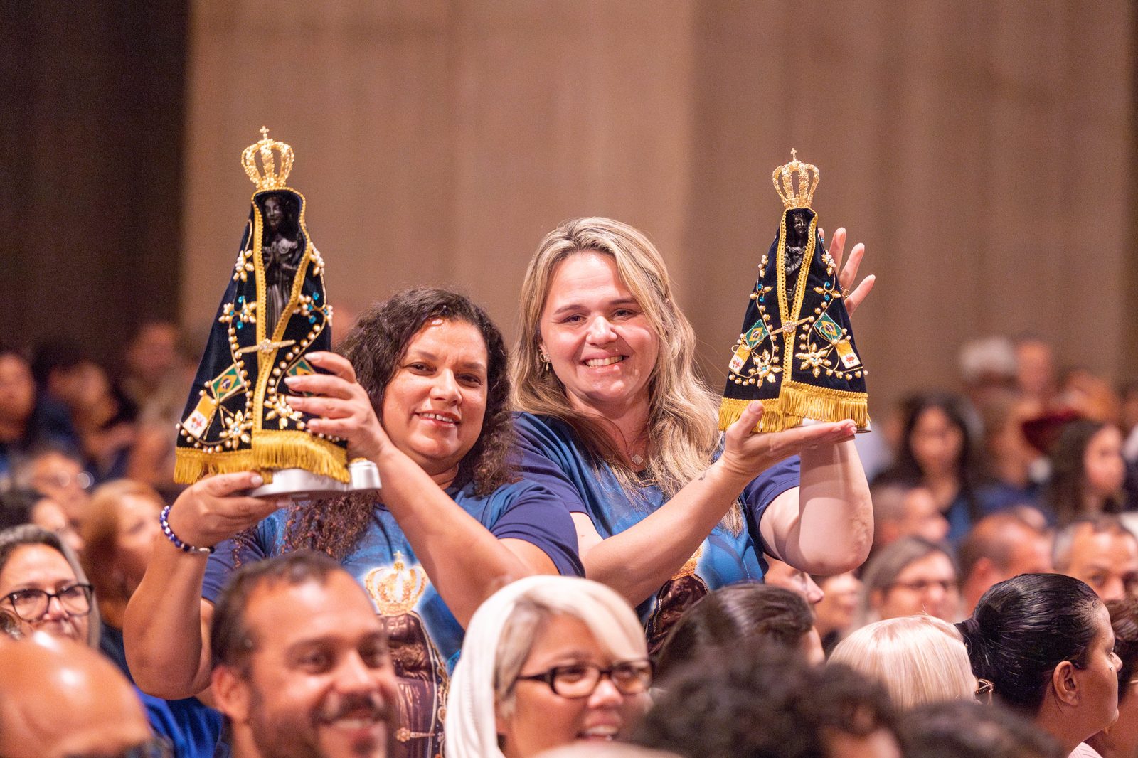 Two Brazilian pilgrims hold replicas of the image of Our Lady of Aparecida before a Sept. 14, 2024 Mass at the Basilica of the National Shrine of the Immaculate Conception for the dedication of a new oratory there honoring the patroness of Brazil. (Carroll Media photo by Mihoko Owada)