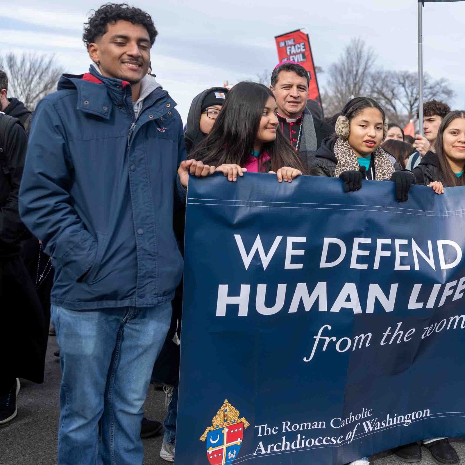 Acompañados por el obispo auxiliar de Washington, Evelio Menjívar (centro, atrás), jóvenes católicos caminan en la Marcha por la Vida el 23 de enero del 2026 hacia la Corte Suprema de Justicia portando su consigna en una gran pancarta que reza: Defendemos la dignidad de la vida humana en todas sus etapas.