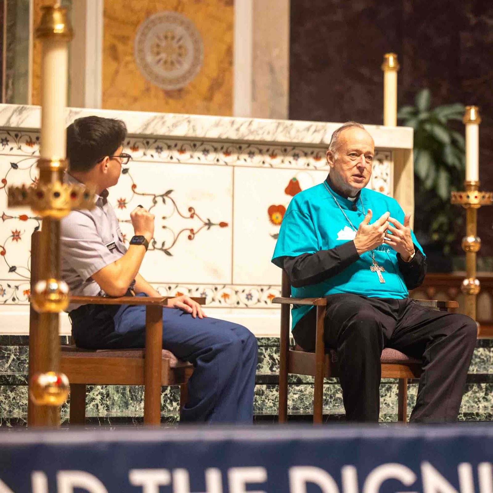 El cardenal Robert W. McElroy, arzobispo de Washington, conversa durante una sesión de preguntas y respuestas con los estudiantes de secundaria Jorge Velásquez de St. John's College High School de Washington, DC, y Andrea Patiño de Academy of the Holy Cross de Kensington, Maryland, antes de la Misa Juvenil por la Vida celebrada en la Catedral de San Mateo Apóstol, el 23 de enero de 2026. Luego del diálogo, los dos estudiantes dieron sus  testimonios sobre la dignidad y el valor de la vida humana.