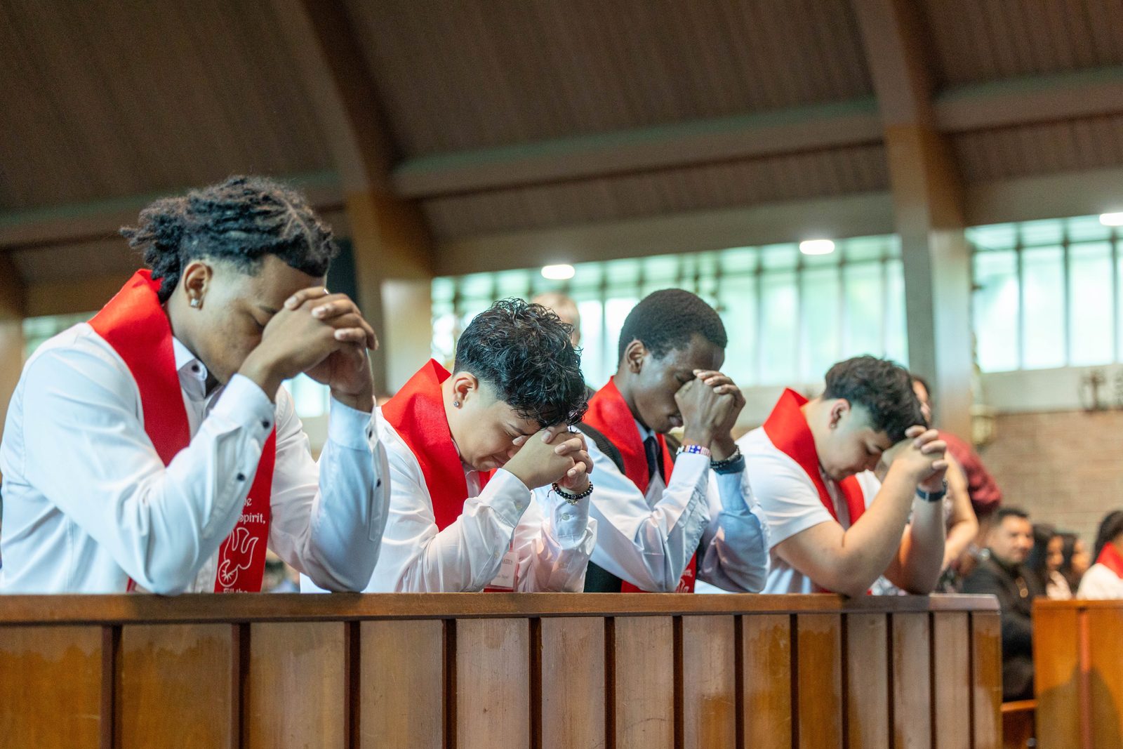 From left to right, students Yandel Fabian, Luis Miguel, Leon Musyimi and Grianny Cruz of Don Bosco Cristo Rey High School in Takoma Park pray during a May 24 Mass at Our Lady of Sorrows Church, where they were among students from their school receiving Sacraments of Initiation. (Catholic Standard photo by Mihoko Owada)